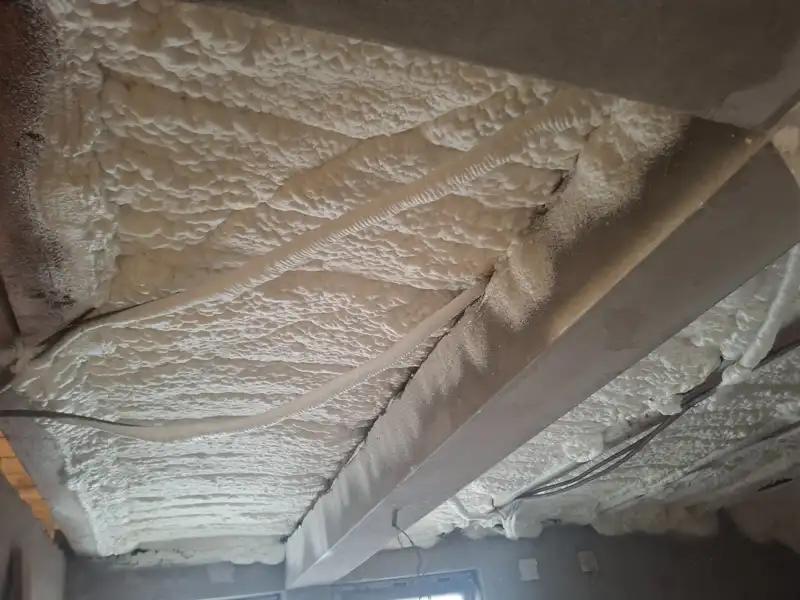 Spumă poliuretanică pulverizată între grinzi de lemn, acoperire completă și etanșare eficientă