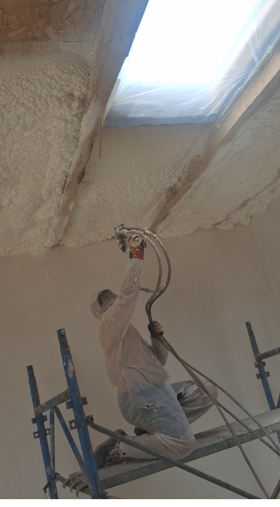 Fereastră Velux protejată cu folie în timpul izolării tavanului cu spumă poliuretanică – lucru pe schelă la înălțime, Domnești, Ilfov